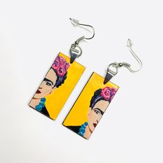 These Frida-inspired earrings are a true work of art, with each element carefully assembled by hand. Made with high quality acrylic paint and protected with a glossy finish, they are not only beautiful but also durable. With their light weight and one-of-a-kind design, they make the perfect gift for someone special. A truly unique accessory for a truly unique person. Size: 3/4 Inch x 1.5 Inch each (without including earrings hook wires).______________________________________ • GET IT FAST!Get it fast! Ready to ship on 1 to 3 business days* • ORDER NOW!Limited Quantities / Limited Edition. • FREE GIFT BOX INCLUDED!Fridamaniacs delivers every jewelry or gift order in a gift box. Thank you for shopping with us!____________________________ * Colors/Designs might slightly vary from actual. Our Artistic Hand Painted Earrings, Artistic Hand Painted Earrings For Gifts, Artsy Yellow Earrings For Pierced Ears, Artsy Yellow Earrings With Artistic Design, Artistic Hand Painted Yellow Earrings, Artistic Drop Earrings, Artistic Adjustable Yellow Earrings, Adjustable Artistic Yellow Earrings, Artistic Yellow Nickel-free Jewelry