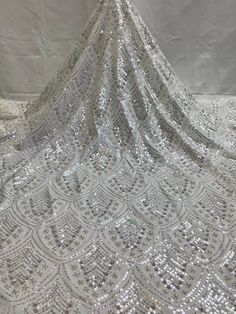 We offer a variety of fashion handmade fabric，those are widely use for wedding dress，garment and fashion cloth. we sell it by yard，our minimum order is 1 yards，and we always package it 15 yards for one roll，the width is 130cm/51 inch Material ： mesh ，Rayon,polyester. Symmetrical embroidery floral pattern, with lovely flowers in the middle, scalloped border. You can also cut and use separately. Perfect for dress, tops, wedding veil. You can split the piece up and have one scalloped edge around th Lace Sequin Dress For Banquet, Silver Sequined Lace Dresses, Silver Sequin Fabric With Lace For Party, Fitted Glamorous Tulle Fabric With Sequins, Silver Sequin Fabric With Lace Work For Party, Silver Fitted Lace Sequin Fabric, Glamorous Fitted Sequined Tulle Fabric, Glamorous Sequin Fabric With Rhinestones For Banquet, Glamorous Sequin Fabric With Rhinestones For Banquets