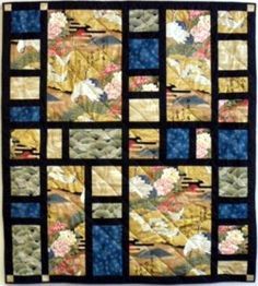 a quilted wall hanging with flowers and leaves on it's sides, along with the blue background