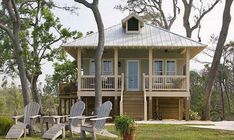 two adiron chairs sitting in front of a small house with porch and wraparound deck