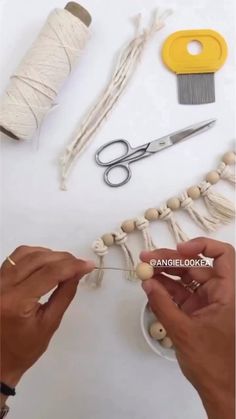 someone is working with yarn and scissors to make a bead necklace on the table