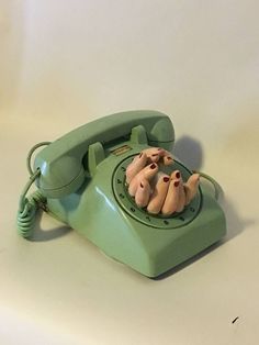 an old green phone with three little pigs on it