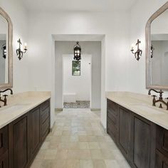 a large bathroom with double sinks and two mirrors on the wall, along with tile flooring