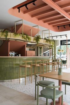 the interior of a restaurant with tables, chairs and plants hanging from the rafters