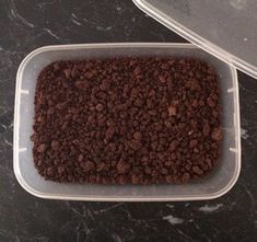 two plastic containers filled with food sitting on top of a black marble counter next to each other