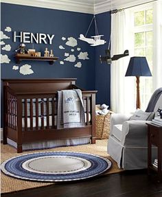 a baby's nursery room with blue walls and white clouds on the wall above it