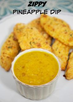 a white plate topped with cheesy bread sticks next to a bowl of dip