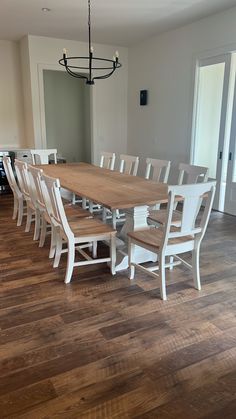 a dining room table with white chairs around it