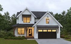 a white two story house with black garage doors and windows at night in the evening