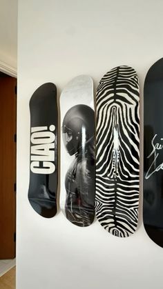 four skateboards mounted to the side of a wall with zebra prints on them,