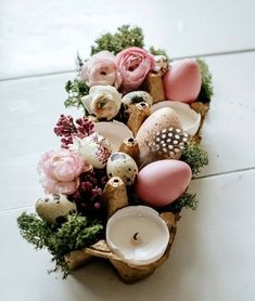 a vase filled with flowers and candles on top of a table