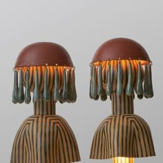 two lamps with tassels on them sitting next to each other