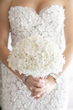 a bride holding a bouquet of white flowers