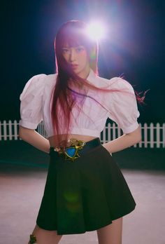 a woman with long hair wearing a white shirt and black skirt