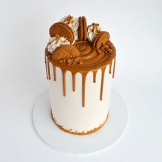 a white cake with chocolate and cookies on top, drizzled in icing