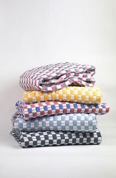 stack of folded shirts on white background with checkerboard pattern in the front and back