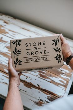 a person holding a box of stone and grove soap