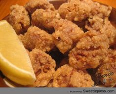 a plate full of fried food with a lemon wedge