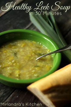 a green bowl filled with soup next to a banana and some other food on a table