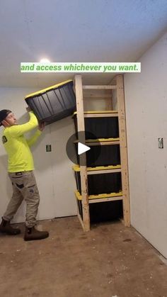 a man in yellow shirt holding up a shelf with black tires on it and another man standing next to him