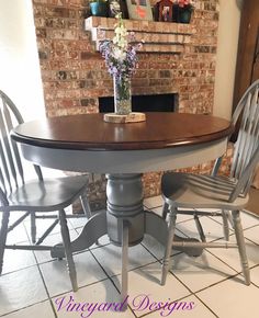 a table with two chairs around it and a vase on top of the dining room table