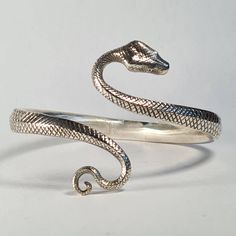 **Please note that we dispatch on Tuesdays unless special delivery express option is paid for** Sterling silver snake bangle. Original design hand carved in wax by Richard then lost wax cast into solid sterling silver. If you desire a different gem to emeralds, please get in touch. We can offer any stone for this design, from onyx straight through to diamond. The bangle size is slightly adjustable as it is a little flexible. First class post included. Afro Jewelry, Snake Ring Gold, Silver Snake Bracelet, Snake Bangle, Silver Cuff Bangle, Wrap Bangles, Snake Jewelry, Snake Bracelet, Indian Jewelry Sets