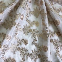 https://neafabrics.com/products/off-white-and-gold-dola-silk-dyeable-fabric-wedding-dress-fabric-multiple-yardage-will-come-in-a-continuous-length-nf863-copy?_pos=1&_sid=a8f1c4504&_ss=r Get FLAT 60% off on above prices at -  ( no additional taxes ) https://neafabrics.com/ White Dupatta With Gold Embroidery For Festivals, White Dupatta With Gold Embroidery For Diwali, Elegant Gold Embroidered Raw Silk Fabric, Gold Silk Dupatta For Eid, Elegant Gold Brocade Saree, White Silk Embroidered Fabric For Party, Elegant White Embroidered Art Silk Fabric, Gold Silk Fabric With Cutdana Embroidery, Gold Embroidered Silk Fabric With Cutdana Details