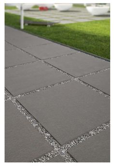 an outdoor walkway with grass and concrete blocks