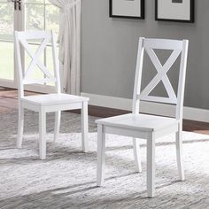 two white chairs sitting on top of a rug