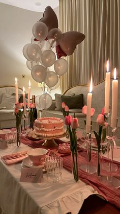 a table with candles, cake and flowers on it