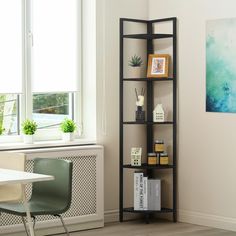 a room with a table, chair and bookshelf in front of a window