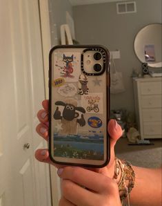 someone holding up their cell phone with some stickers on it in front of the camera