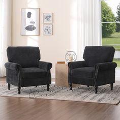 two black chairs sitting on top of a rug in a living room next to a window