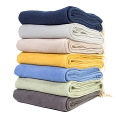 several folded towels stacked on top of each other in different colors and sizes, with one folded