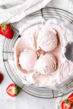 homemade strawberry ice cream in a bowl with strawberries on the side and text overlay that reads homemade strawberry ice cream