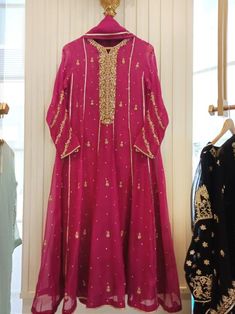 Turned heads in this beautiful fuchsia pink. Hand crafted to perfection. Adorned on pure organza in a flowy gown, with delicate handwork in gotah, dabka, sequins and crystals, paired with straight raw silk trousers and pure organza dupatta. An ideal look for festivities’   Delivery Time: 4 to 8 weeks Hand Embellished Organza Anarkali Set For Festivals, Eid Hand Embellished Organza Anarkali Set, Festival Hand Embellished Organza Anarkali Set, Pink Silk Hand-embellished Sets, Pink Hand Embellished Silk Set, Hand Embellished Pink Silk Set, Pink Hand Embellished Organza Lehenga, Red Organza Anarkali Set With Dabka, Red Organza Anarkali Set With Dabka Detail