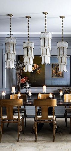 an elegant dining room with chandeliers hanging from the ceiling and candles on the table