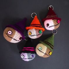 four crocheted halloween ornaments with eyes and hats on them are arranged in a circle