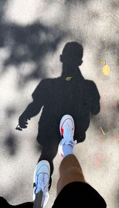 two people standing next to each other with their shadows on the ground and one person's shadow