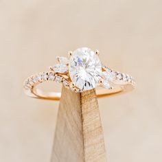 a close up of a diamond ring on top of a wooden stand