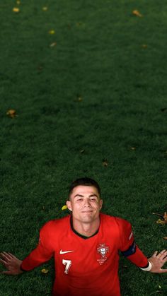 a man laying on top of a lush green field