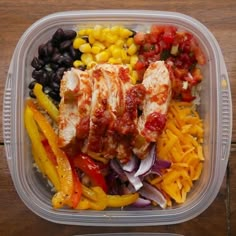 a plastic container filled with chicken, black beans, corn and veggie salad