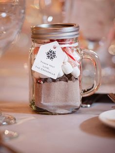 a jar filled with candy canes and marshmallows on top of a table