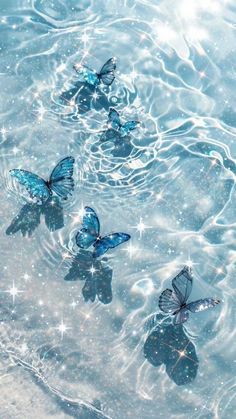 three blue butterflies floating in the water with sparkles on them'backs and wings