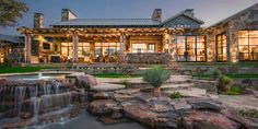 a large house with a waterfall in front of it