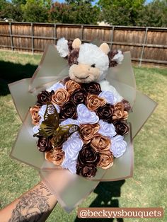 a teddy bear holding a bouquet of flowers in it's hand with a butterfly on top