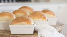 several white loafs of bread sitting on top of a wooden table