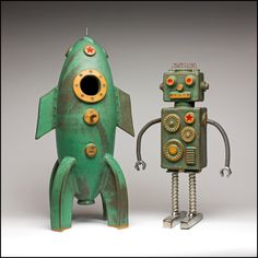 an old fashioned robot next to a green toy