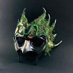 Venture into the heart of the enchanted woods with our Forest Emerald Ent Mask. Adorned with lush green moss and creeping vines, this mask embodies the spirit of ancient forest guardians, perfect for nature-themed events or mystical gatherings. Additional product details: All our masks come with Ribbons or elastic bands attached unless it’s a handheld stick mask Size/Type: One Size Fits Most Mask Color: Dark Green with Natural Accents Mask Material: High-Quality Resin and Natural Moss Accent Mat Mardi Gras Kid, Kids Party Packs, Creeping Vines, Enchanted Wood, Female Mask, Mask Masquerade, Ancient Forest, Themed Events, Type One