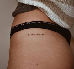 One Word Tattoos | Tattoofilter Amor Tattoo On Hip, Small Tattoos For Women Hip Bone, Amor Hip Tattoo, Words Hip Tattoo, Hidden Hip Tattoo, Danty Tattoos Small On Hip, Hip Area Tattoo, One Word Hip Tattoo, Hip Writing Tattoos Women